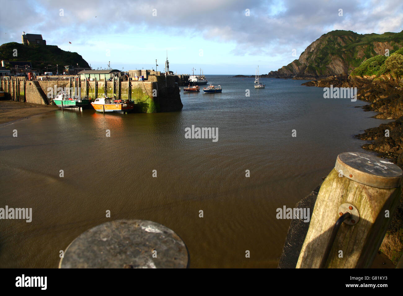 Last rays of sunshine strike the quay at Ilfracombe as the tide turns Stock Photo