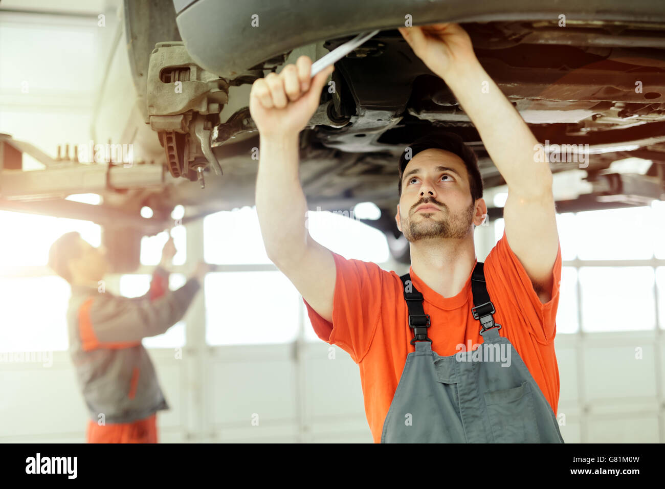 Car mechanic upkeeping car in dealership garage Stock Photo Alamy