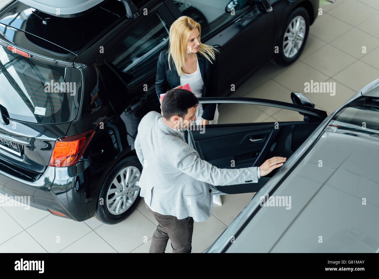 Elegant salesperson working at car dealership Stock Photo