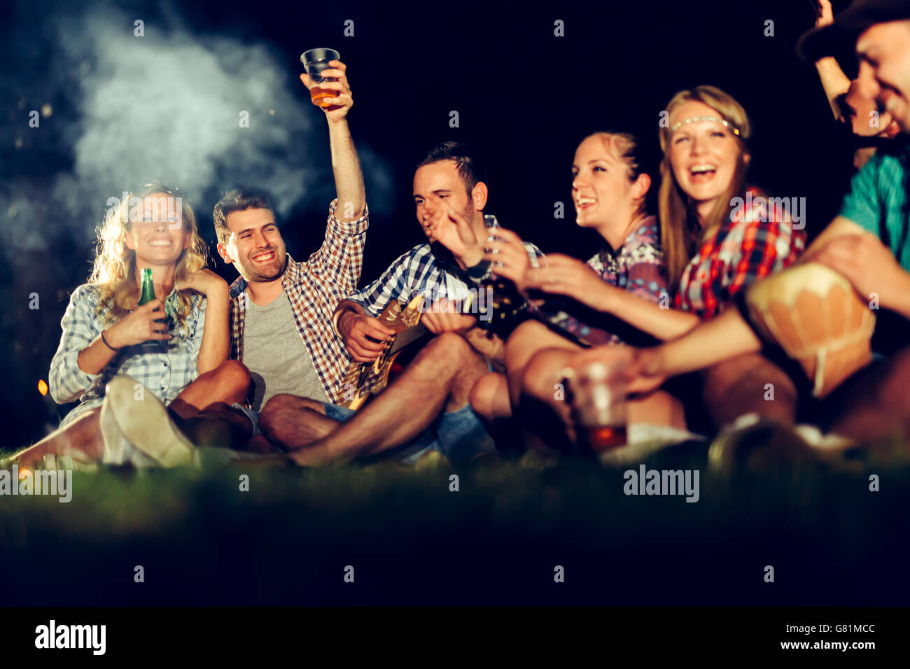 Friends having bonfire party and drinking beer Stock Photo - Alamy