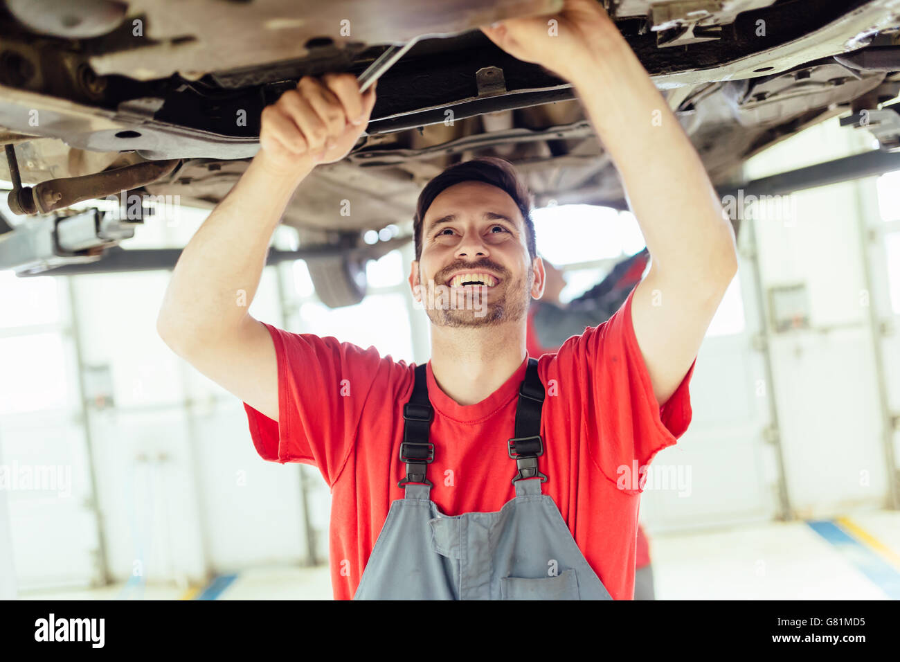 Car mechanic upkeeping car in dealership garage Stock Photo Alamy