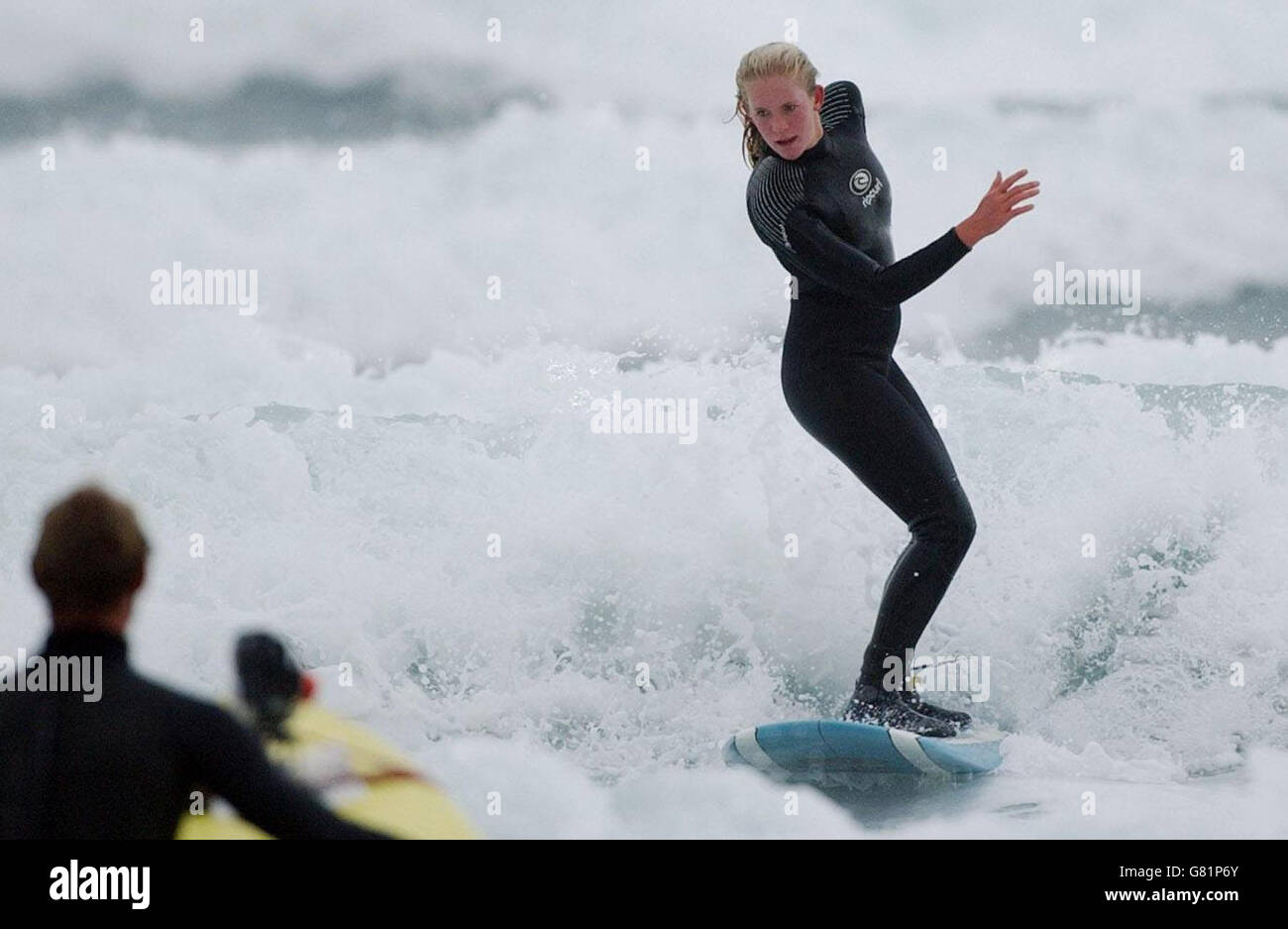 Bethany Hamilton, 15, takes to the waves in Watergate Bay, near Newquay, where she was teaching new Blue Peter presenter Gethin Jones, 26, to surf for a future episode of the children's TV programme. The teenage surfer from Hawaii lost her left arm when she was attacked by a 14ft tiger shark while she was surfing near Tunnels Beach on Kauai on October 31, 2003, when she was 13. Stock Photo
