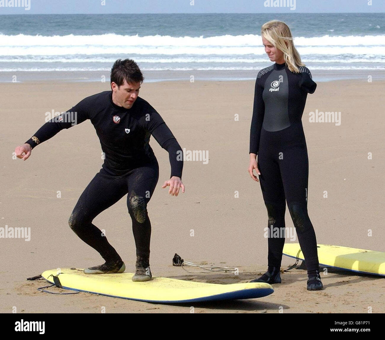Bethany Hamilton, 15, gives some surfing tuition to new Blue Peter presenter Gethin Jones, 26, on the beach at Watergate Bay, near Newquay, where she was teaching new Blue Peter presenter Gethin Jones, 26, to surf for a future episode of the children's TV programme. The teenage surfer from Hawaii lost her left arm when she was attacked by a 14ft tiger shark while she was surfing near Tunnels Beach on Kauai on October 31, 2003, when she was 13. Stock Photo