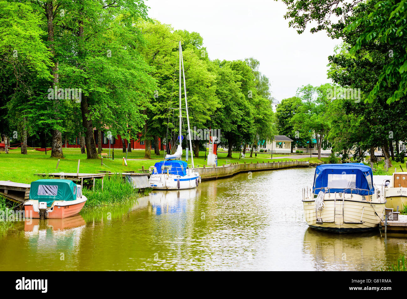 Soderkoping, Sweden - June 20, 2016: Boats moored in the Storan river with public park beside the pier. Stock Photo