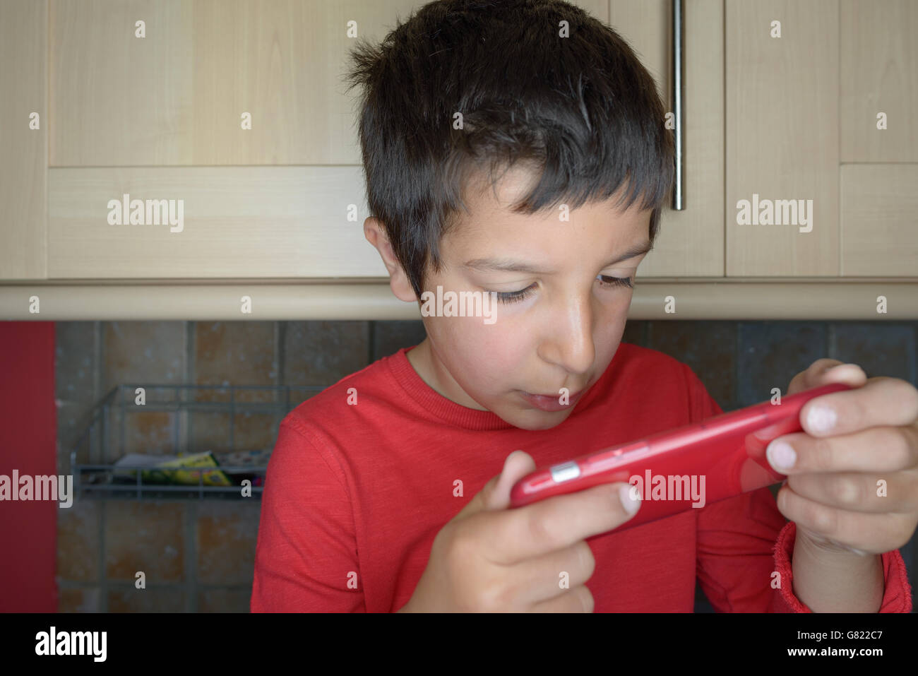 Boy plays games on mobile phone Stock Photo