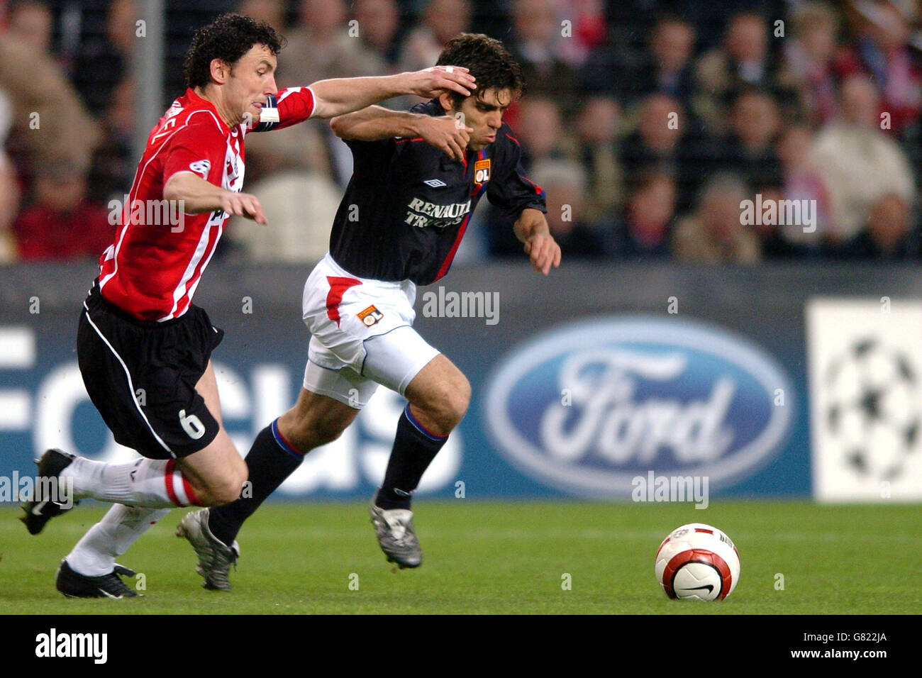 PSV Eindhoven's Mark Van Bommel and Olympique Lyonnais' Juninho Pernambucano (r) battle for the ball Stock Photo