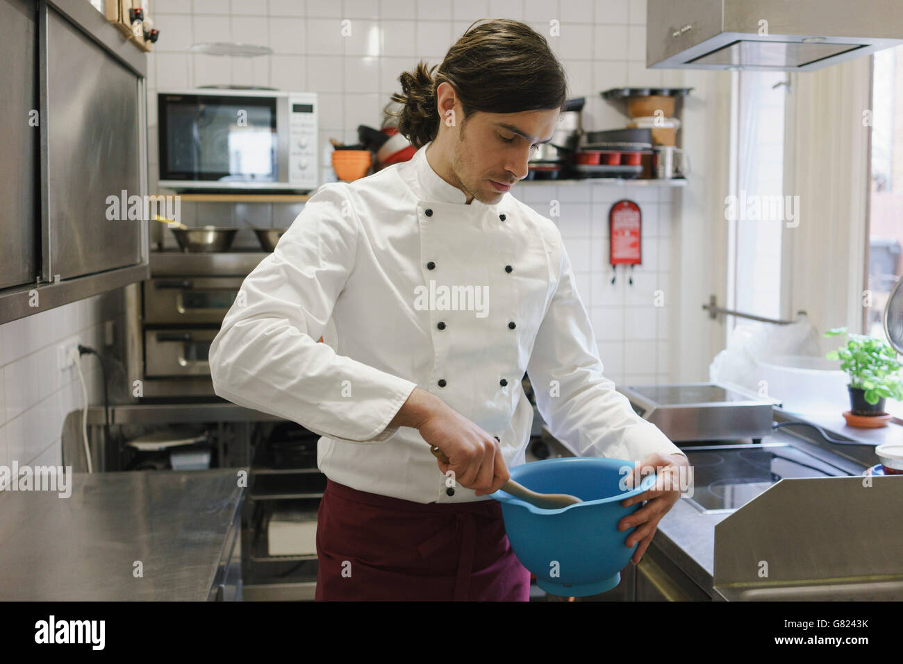 Chef cooking in commercial kitchen at cafe Stock Photo Alamy