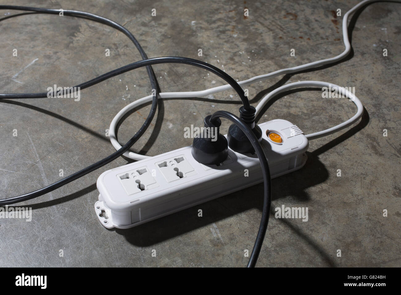 High angle view of cables connected to electric plug on floor Stock Photo