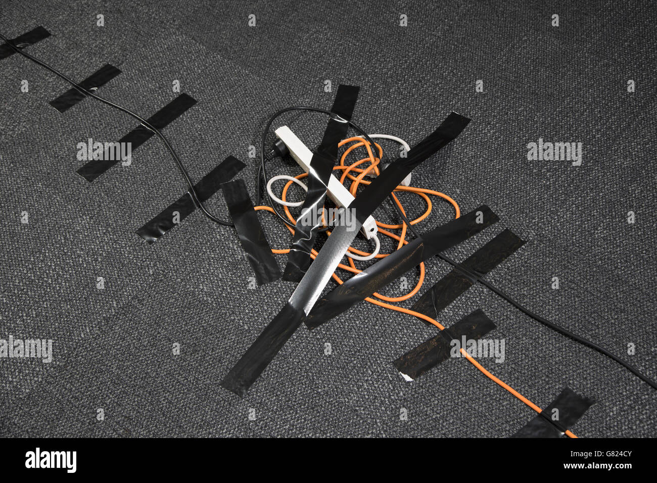 High angle view of cables and electric plug attached on black carpet Stock Photo