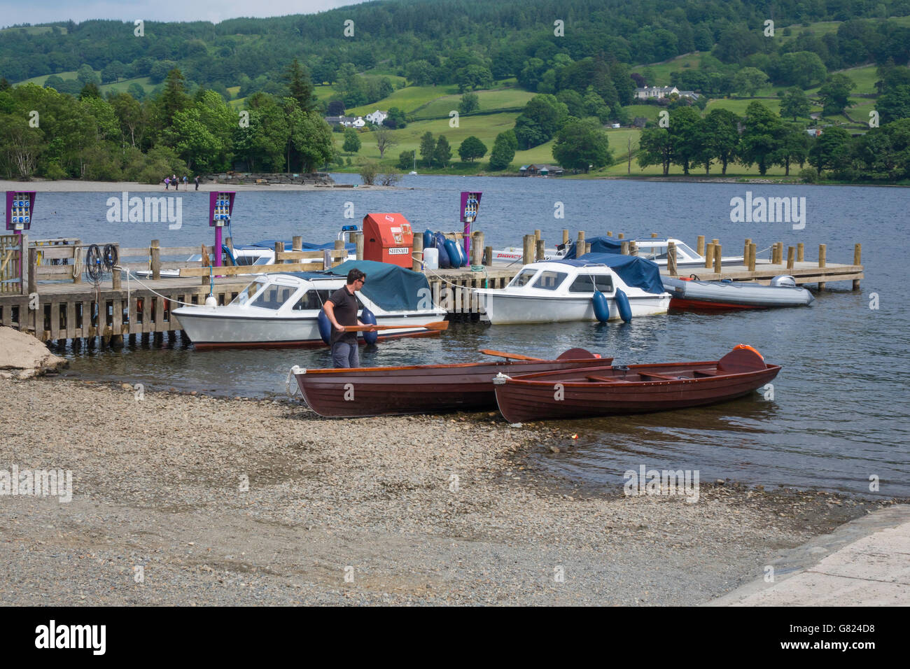 Electrically powered motor boats with charging points and traditional wooden skiffs for hire at Coniston Water Cumbria UK Stock Photo