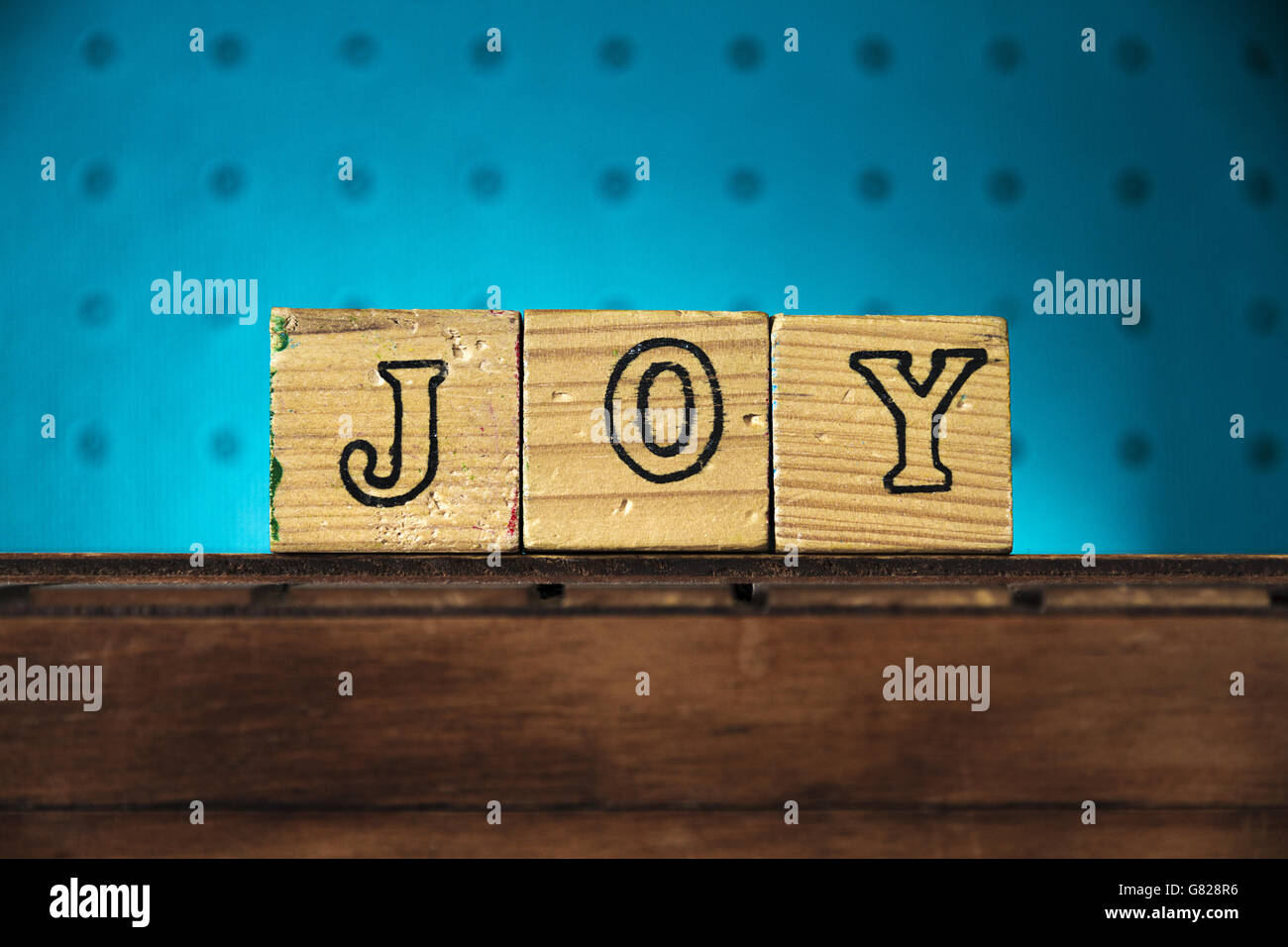 The word 'joy' spelled with letters on wooden toy blocks Stock Photo