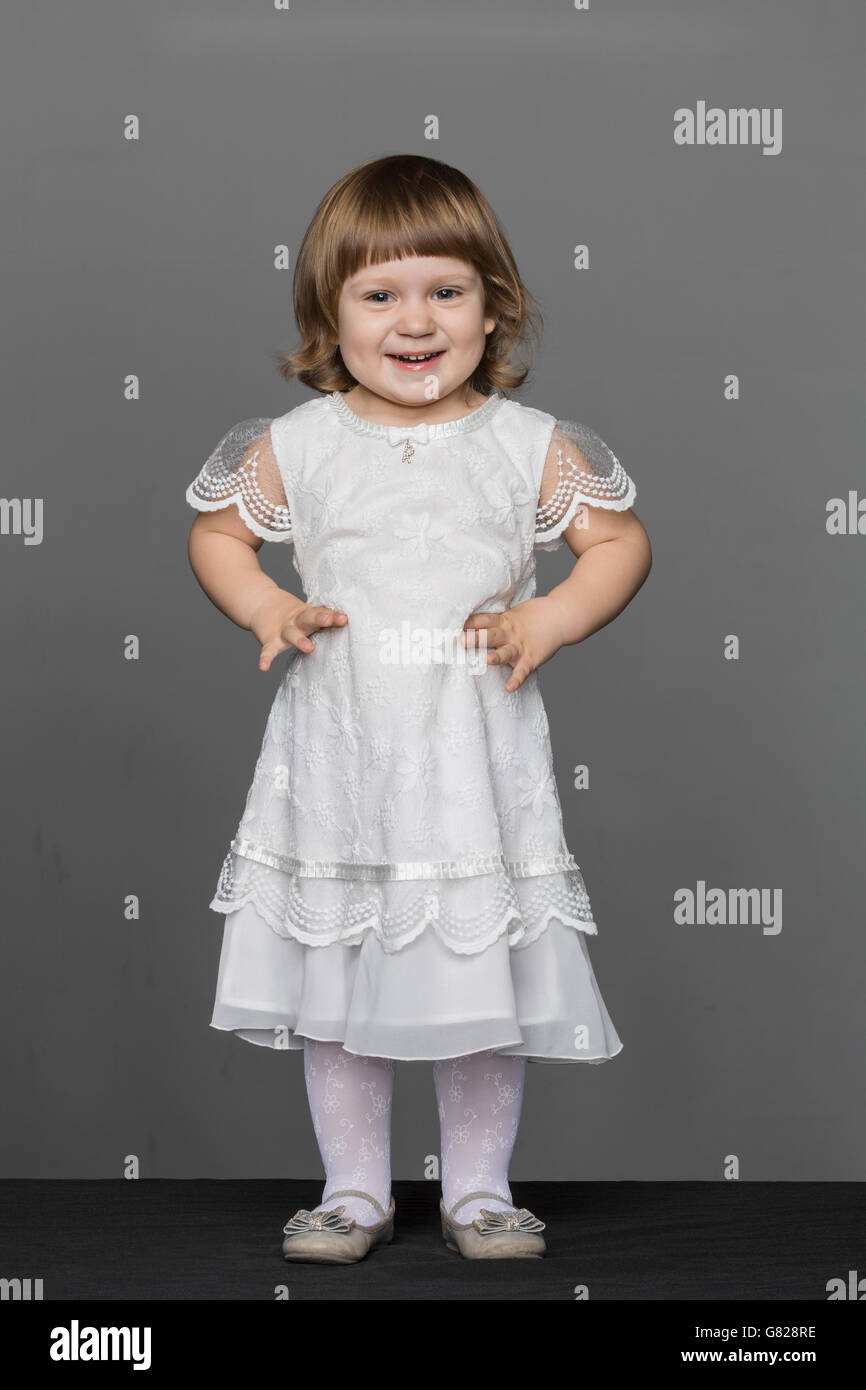 Portrait of happy girl while standing against gray background Stock Photo