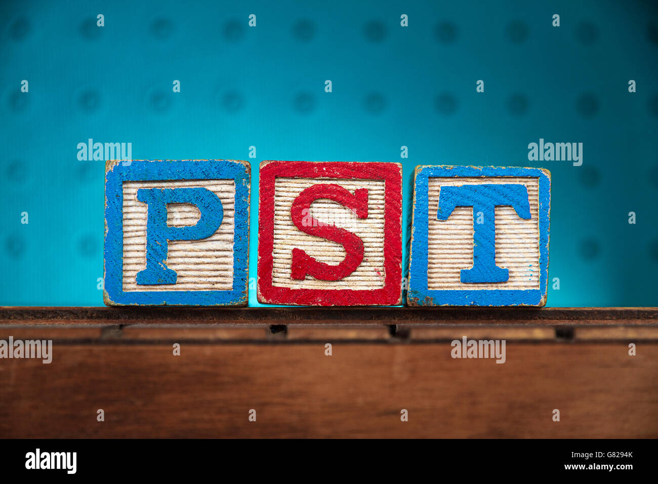 The word 'pst' spelled with letters on wooden toy blocks Stock Photo