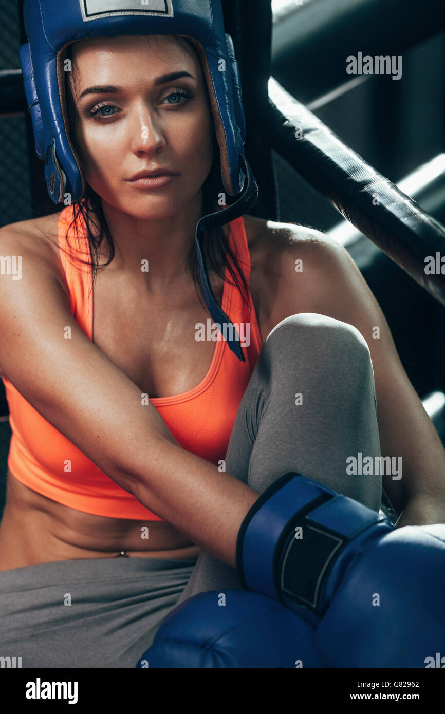 Female boxer sitting at corner in boxing ring Stock Photo