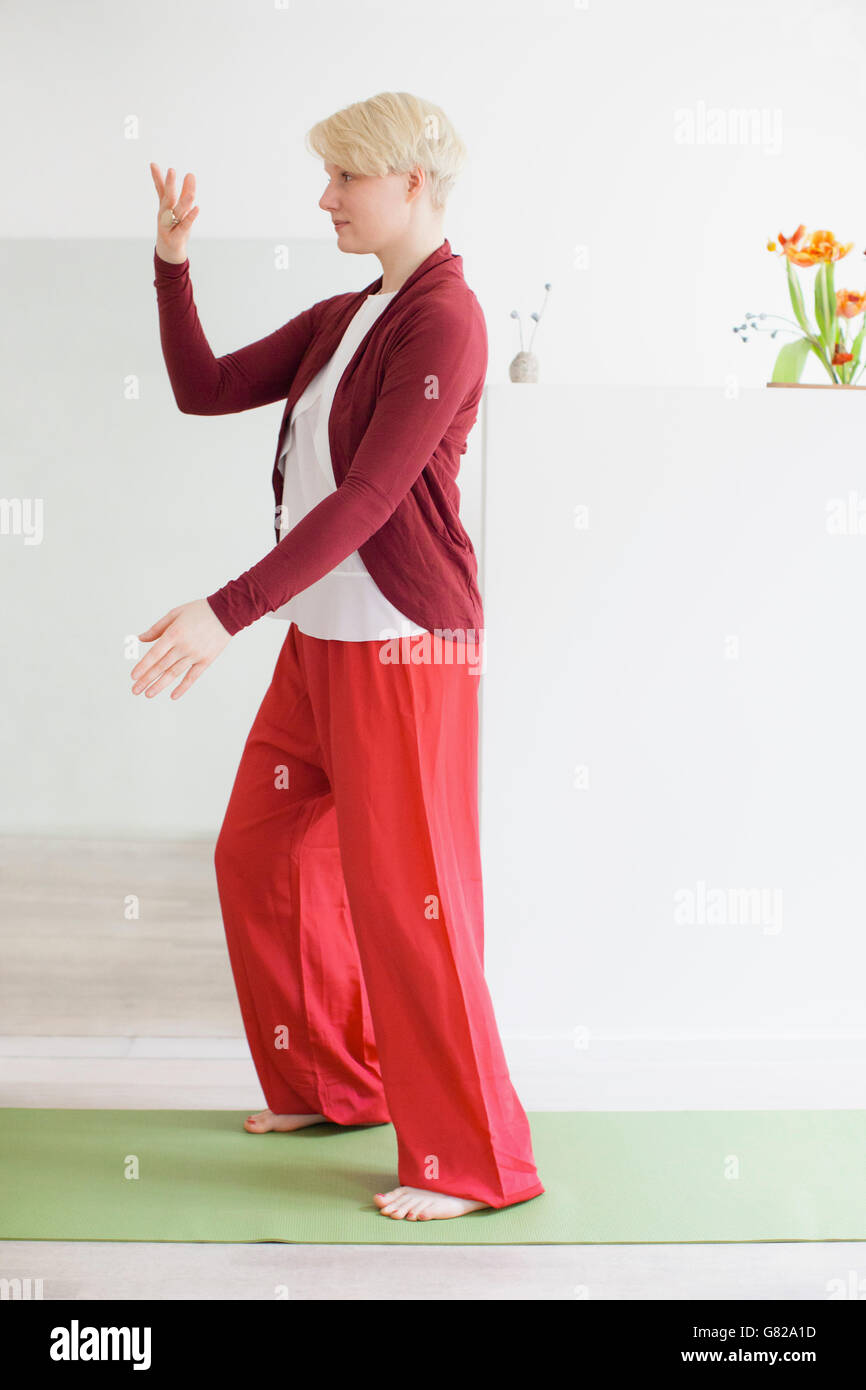 Full length side view of a fit young woman stretching body in exercise ...