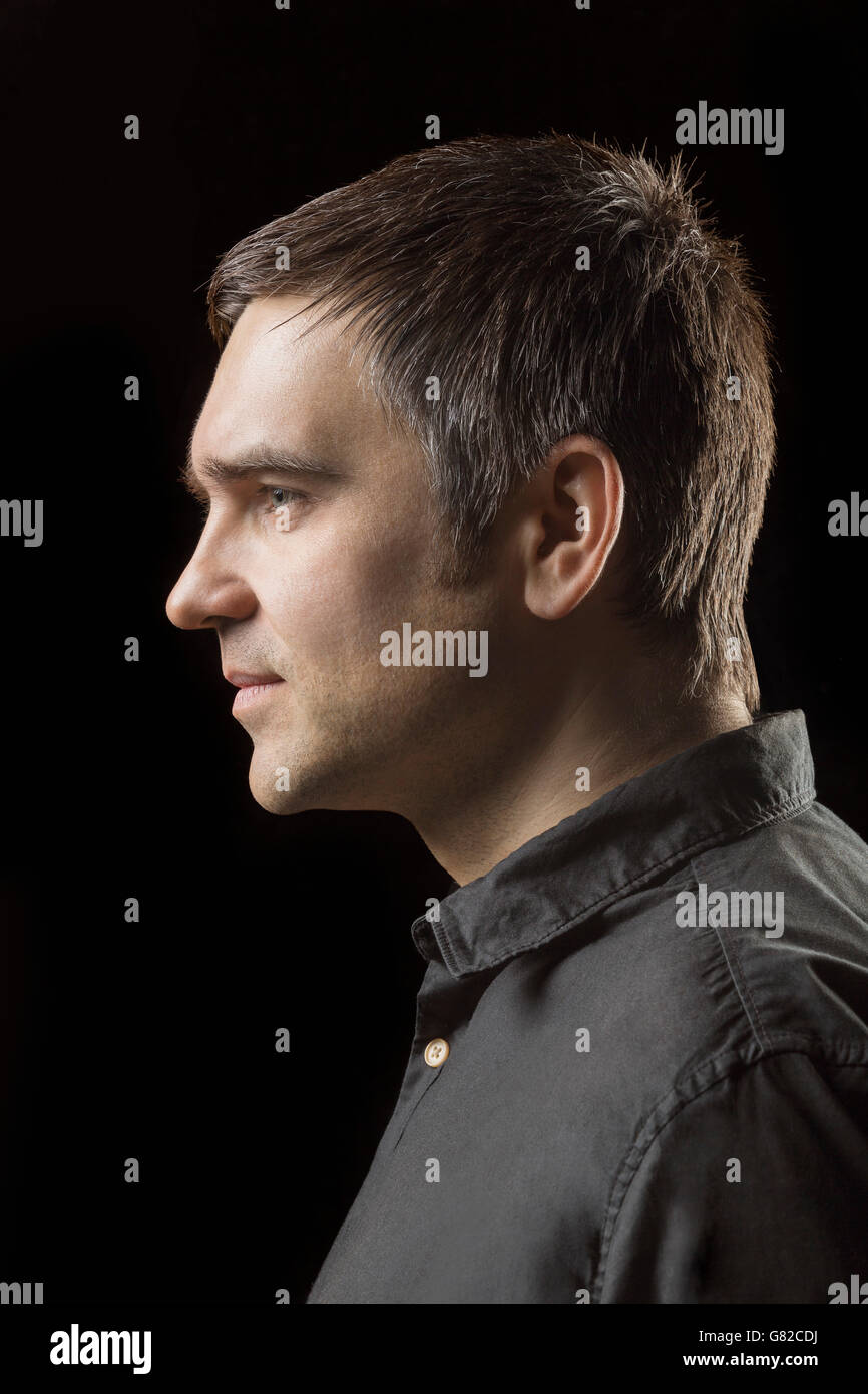 Profile view of man against black background Stock Photo