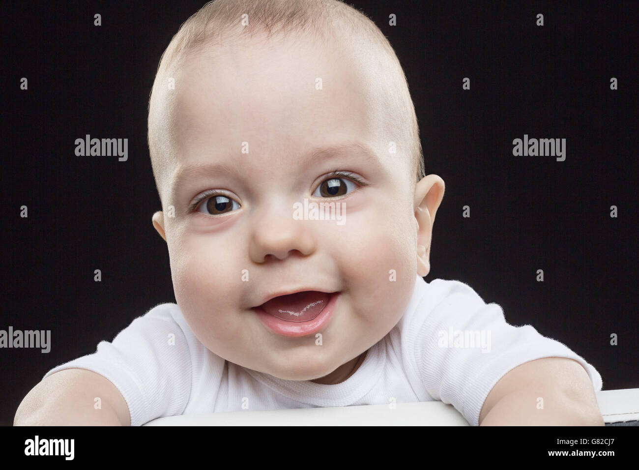 Portrait of happy baby boy against black background Stock Photo