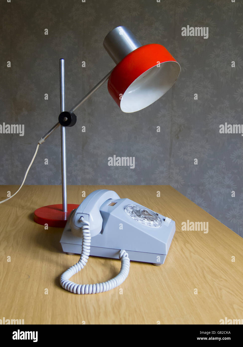 Rotary phone and electric lamp on table at home Stock Photo