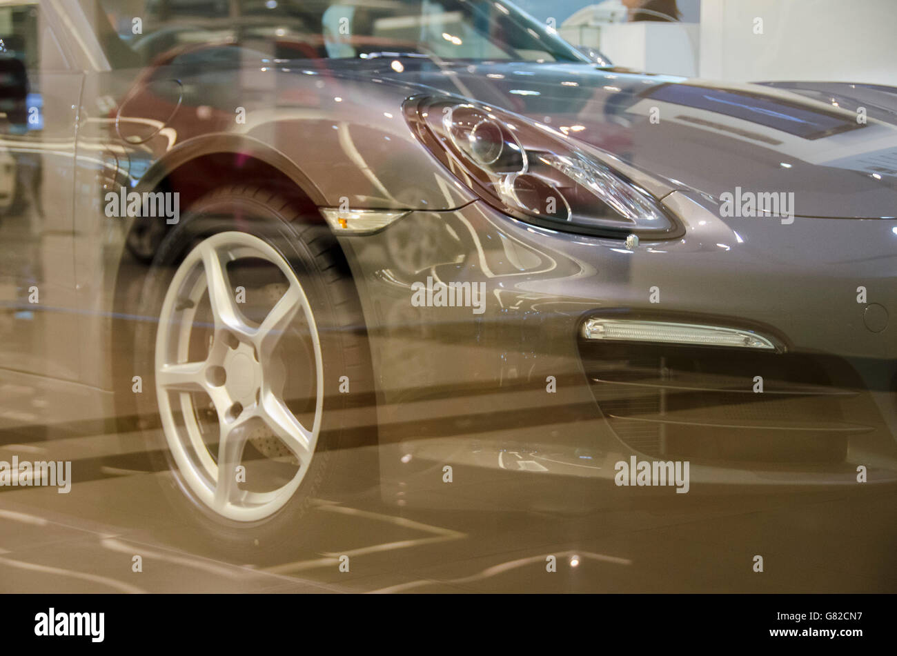 Cropped image of car seen through glass at showroom Stock Photo