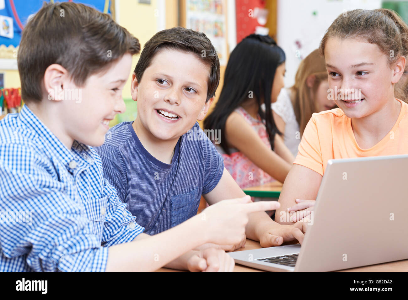 Group Of Elementary School Children Working Together In Computer Class Stock Photo