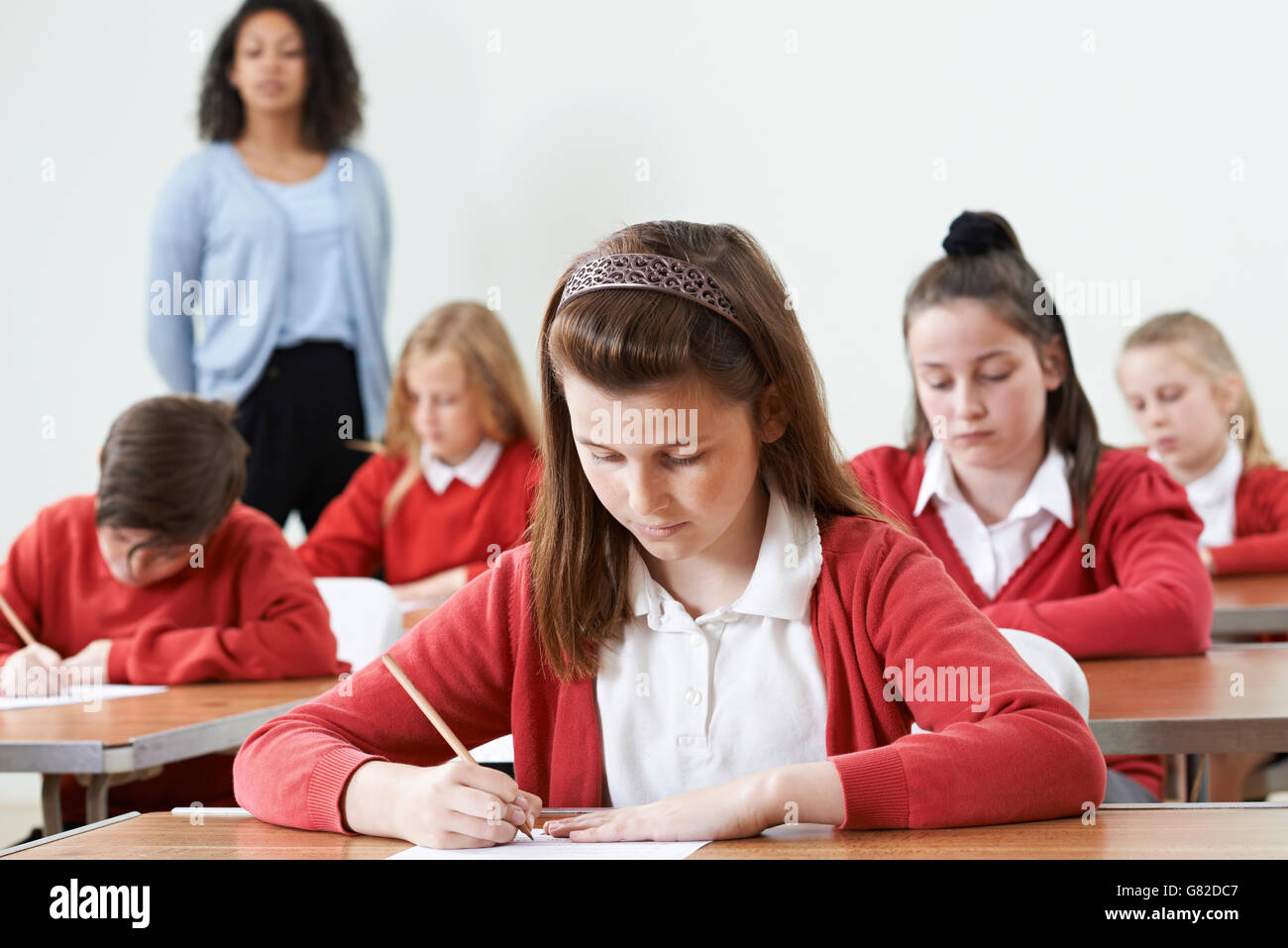 Female Pupil At Desk Taking School Exam Stock Photo