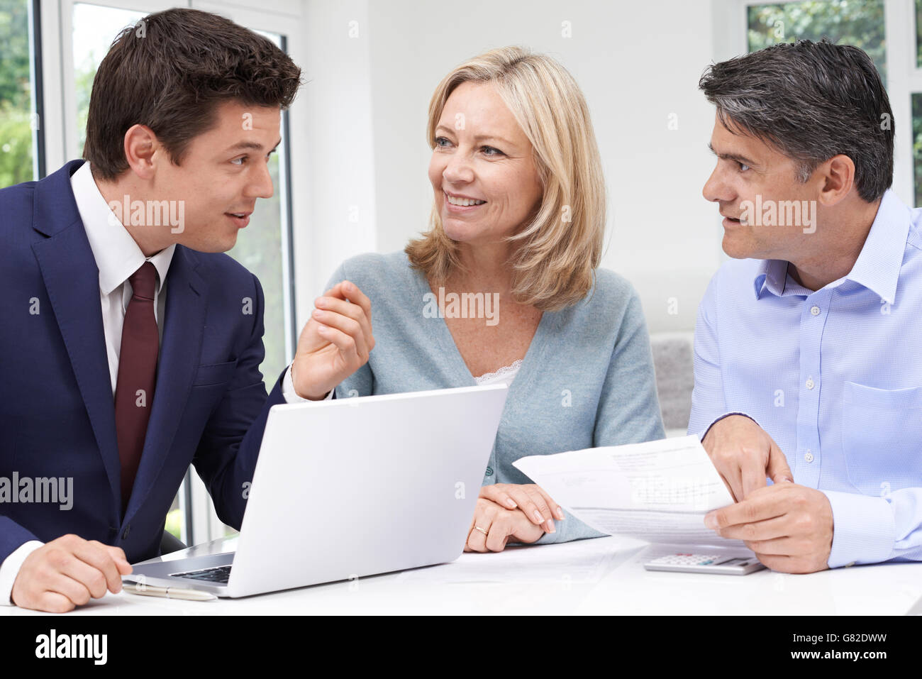 Mature Couple Meeting With Financial Advisor At Home Stock Photo