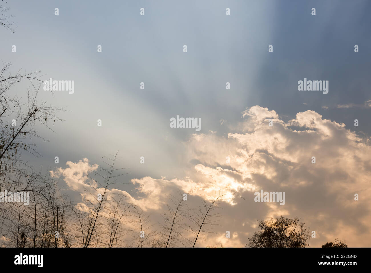 Sun rays shining through cloud on sunset sky Stock Photo - Alamy