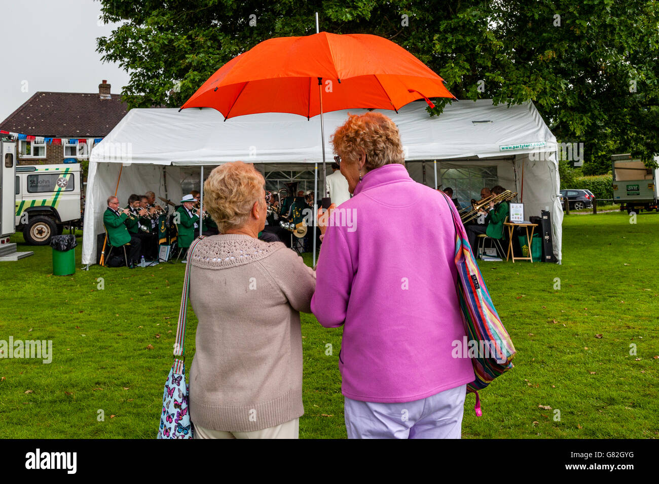 Two Women Watch A Brass Band Play At The Annual Village Fete In Nutley