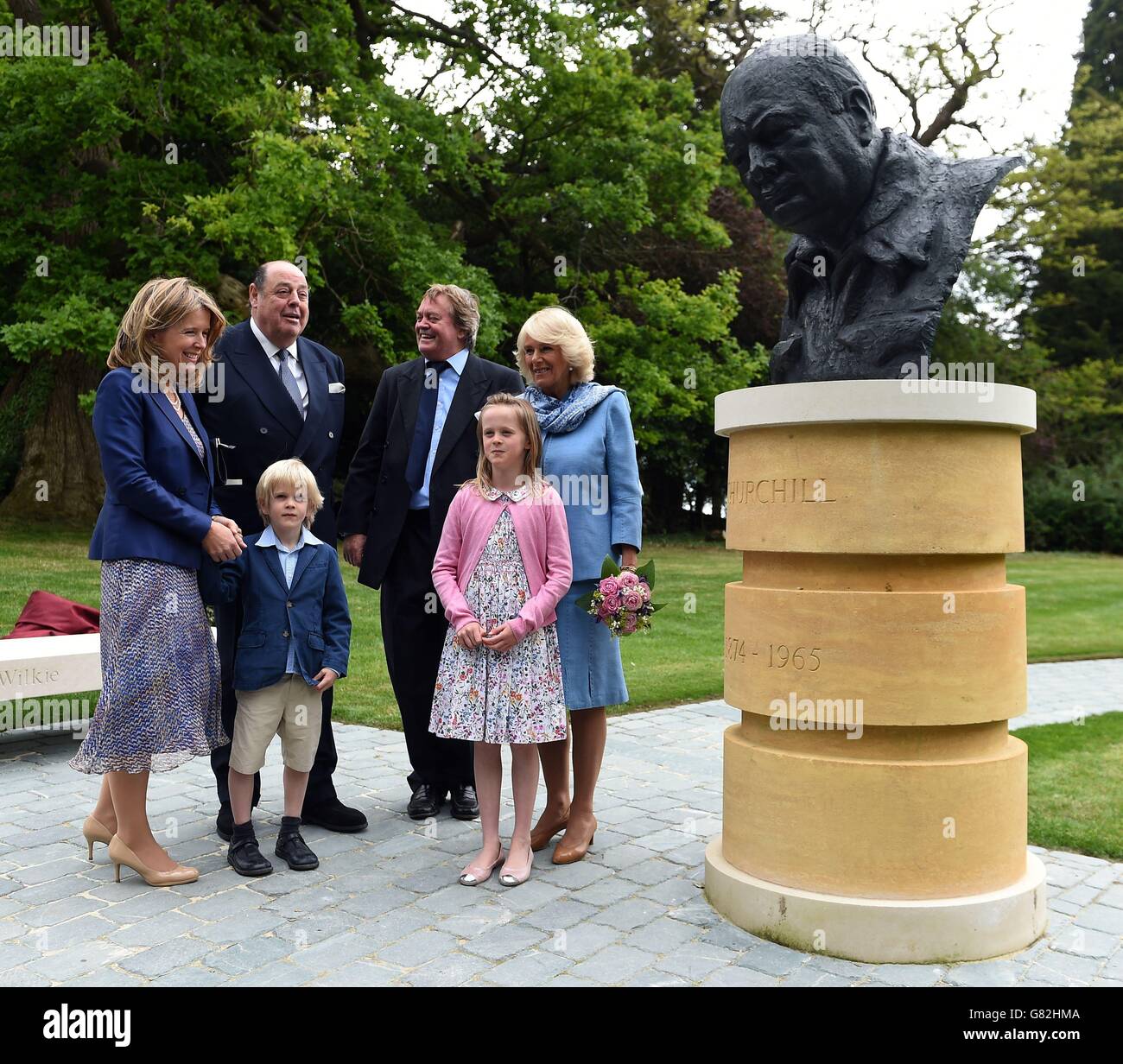 The Duchess of Cornwall (right) with Sir Nicholas Soames MP (second left) along with The Duke of Marlborough, Jamie Spencer-Churchill (third right) his wife Edla Griffiths (left), his son Lord Caspar Spencer-Churchill (third left) and daughter Lady Araminta Spencer-Churchill stand next to a newly unveiled bust of Sir Winston Churchill in the grounds of Blenheim Palace, Oxfordshire. Stock Photo