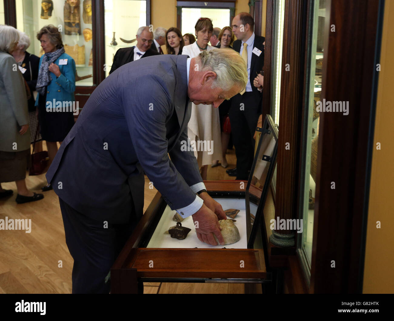 The Prince of Wales places an historic artifact of a marble head of a young man from a Greek relief, which dates from late fifth to early fourth century BC, into a display cabinet during a visit to Eton College near Windsor, Berkshire where he officially opened the new Bekynton Field Development building. Stock Photo