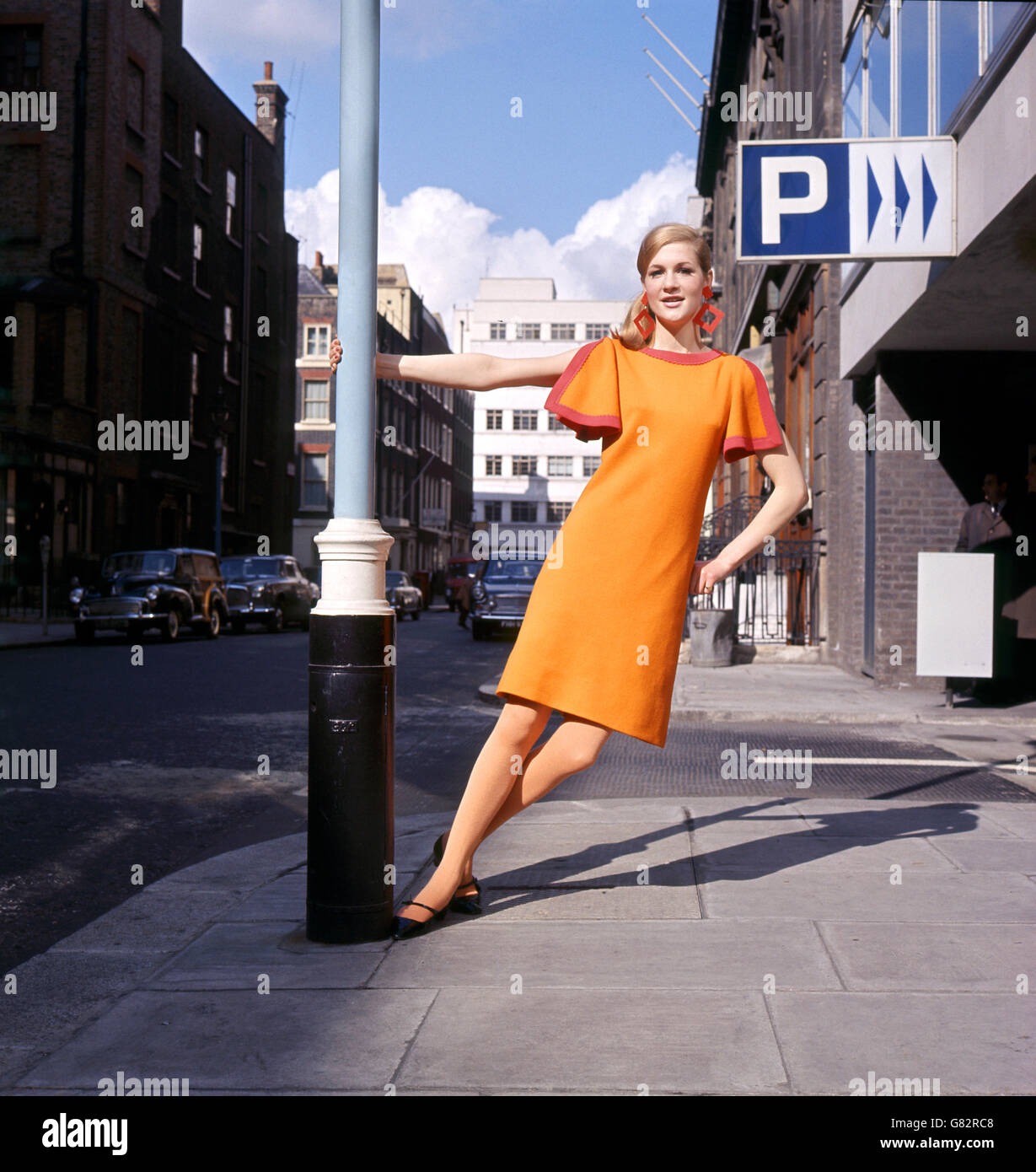 Orange dress in wool jersey worn with yellow stockings is one of the styles of Italian Knitwear Fashions flown to London for a special exhibition at the Italian Trade Centre, Old Burlington Street. Stock Photo