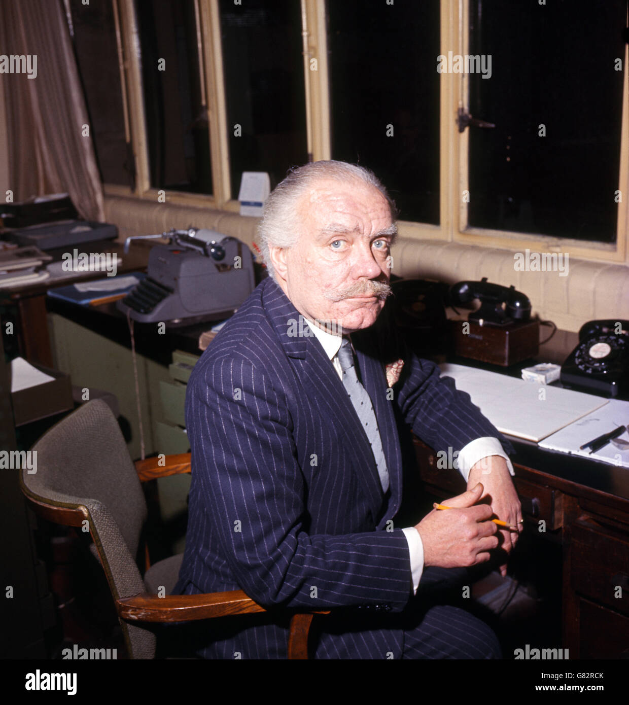 English cartoonist, author, art critic, stage designer and Daily Express cartoonist Osbert Lancaster sat at his desk. Stock Photo