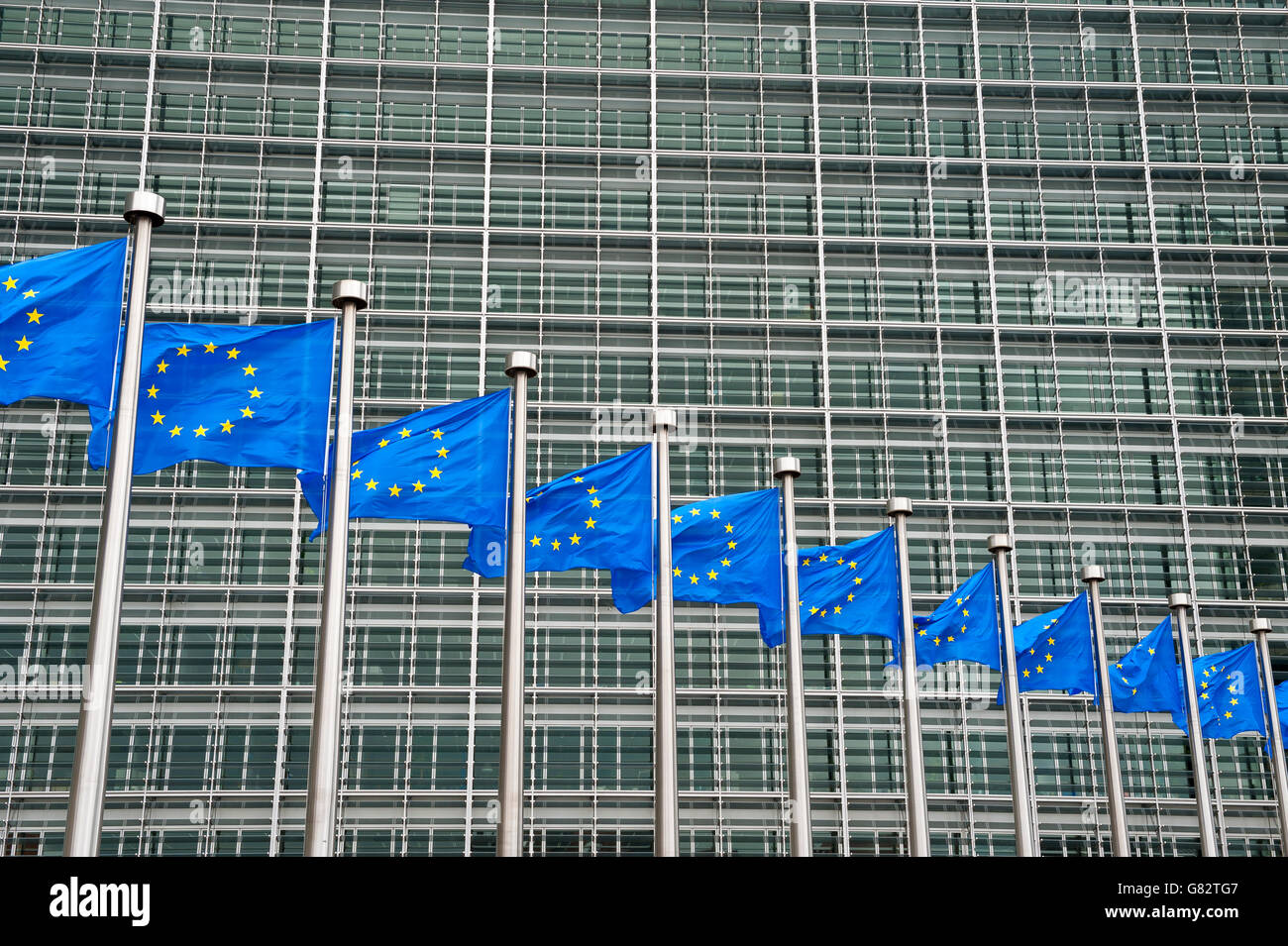 Row of EU European Union flags flying in front of administrative building at the EU headquarters in Brussels, Belgium Stock Photo