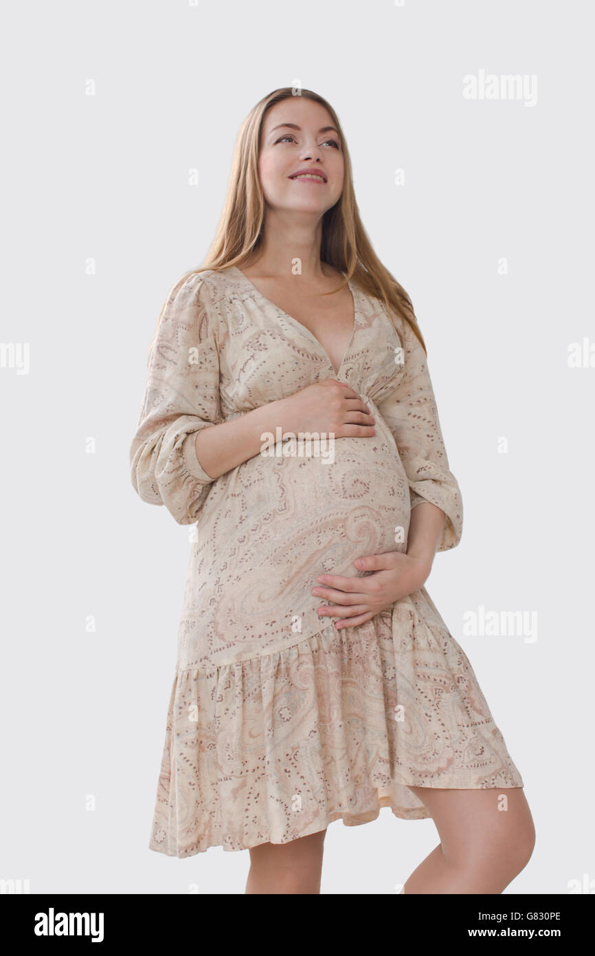 Smiling pregnant woman holding her belly Stock Photo - Alamy