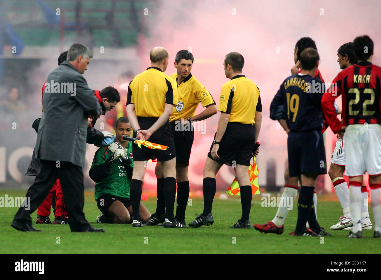 Referee Markus Merk decides to take the players off the field after flares  and bottles were