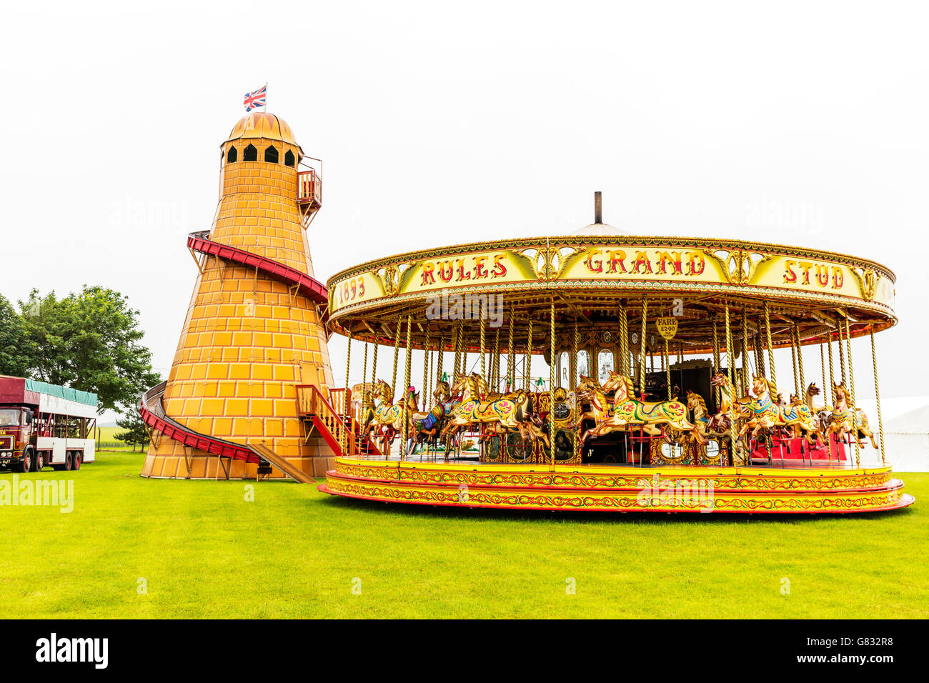 Helter skelter merry go round fair fairground rides ride attraction attractions fairs UK England GB Stock Photo