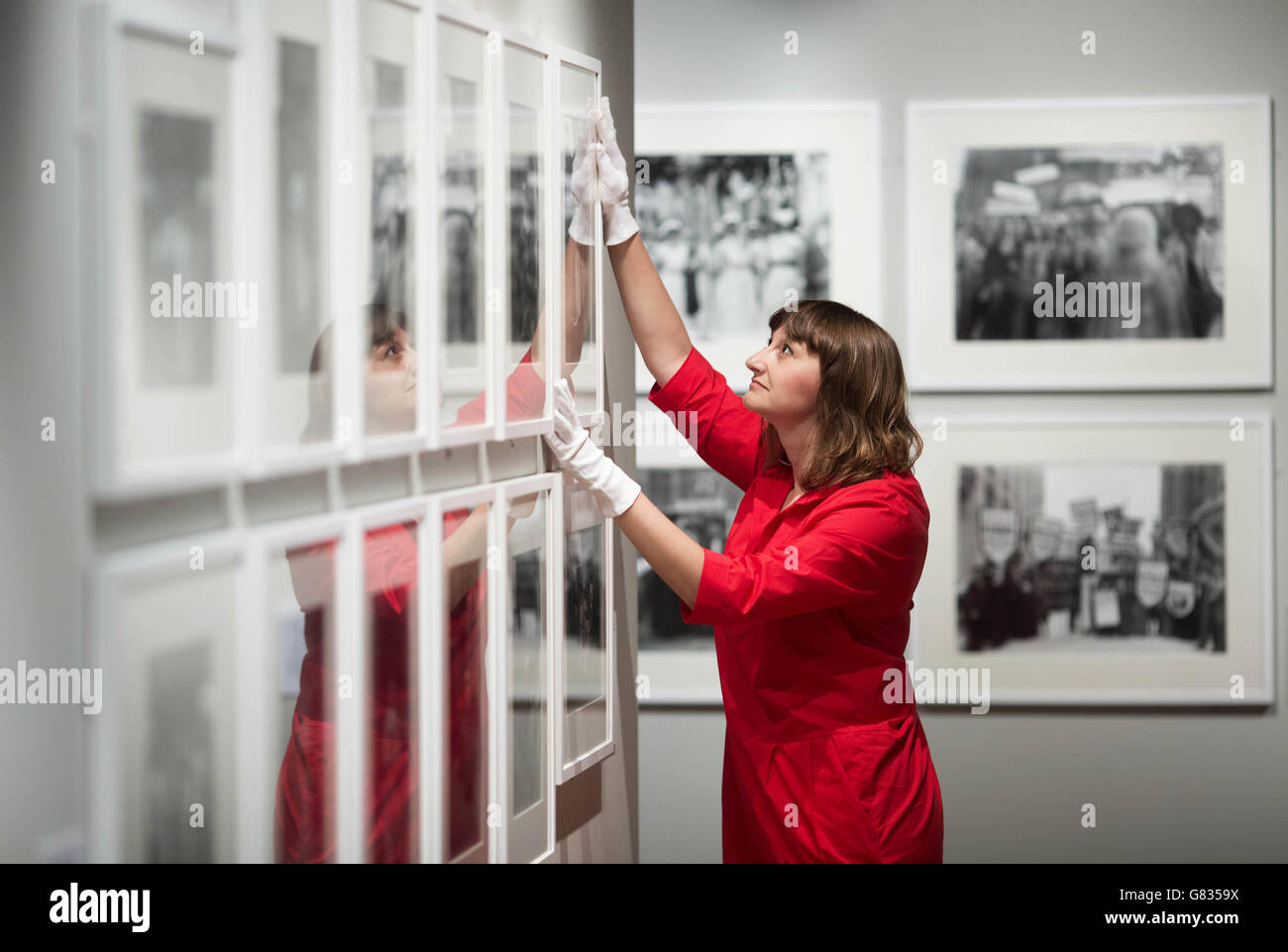 EDITORIAL USE ONLY Exhibition curator Anna Sparham inspects a display at the Museum of London Docklands ahead of the opening of their latest exhibition Soldiers and Suffragettes: The Photography of Christina Broom, a free exhibition opening to the public from Friday 19th June. Stock Photo