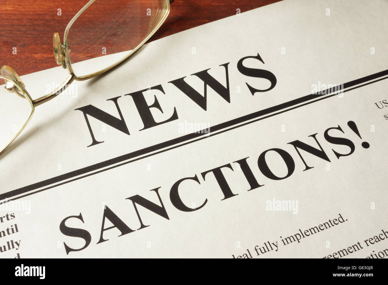 Newspaper with word news and sanctions. Stock Photo