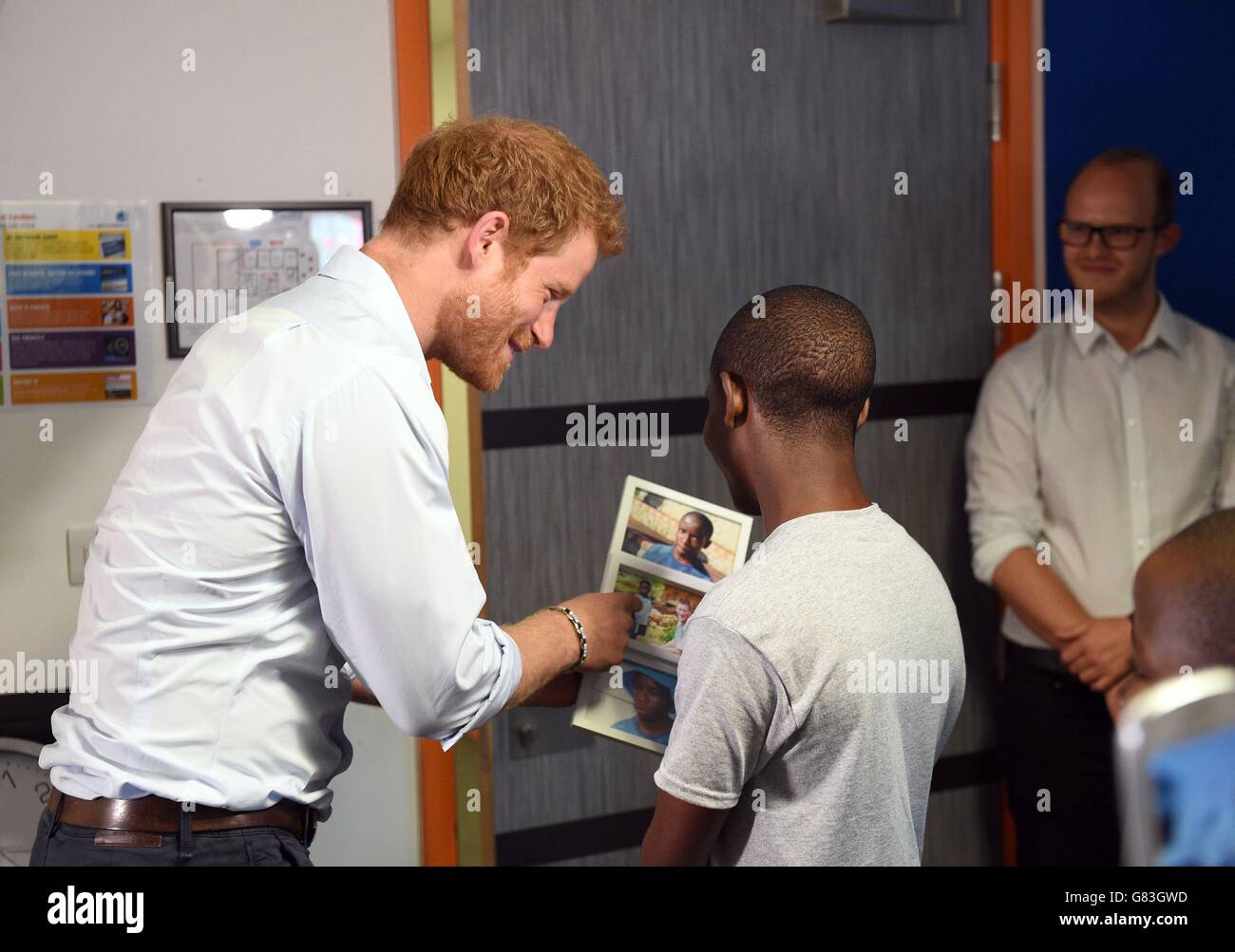 Prince Harry (left) is looks at photos with Relebohile 'Mutsu' Potsane after watching members of the Basotho Youth Choir during their rehearsals at the Brit School ahead of a performance at the Sentebale Concert. Stock Photo