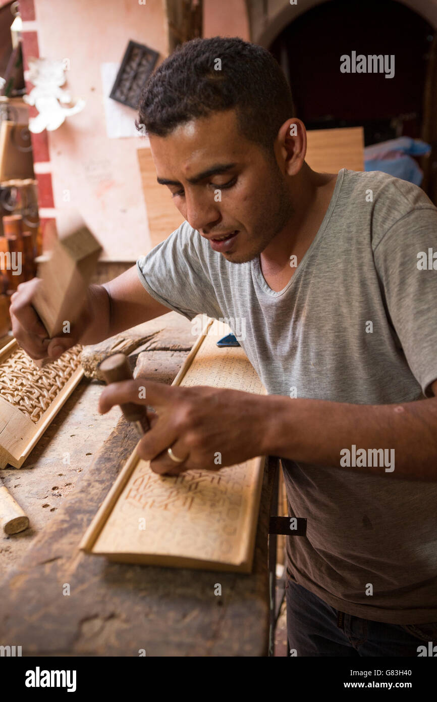 A woodworker artisan works in his workshop in the Marrakesh Medina, Morocco. Stock Photo
