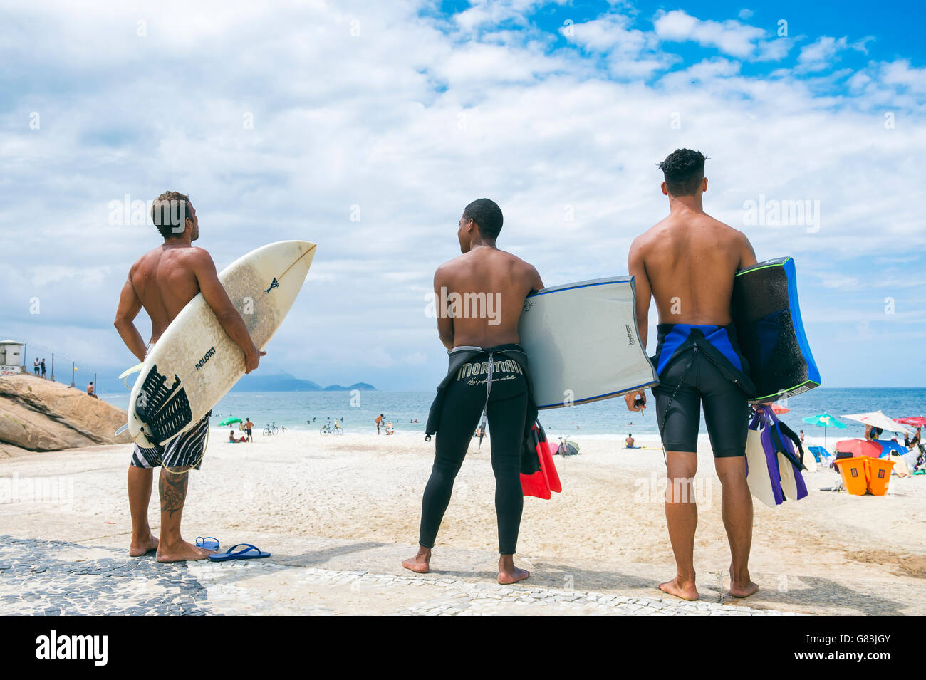 RIO DE JANEIRO - APRIL 3, 2016: Group of young Brazilian carioca surfers stand on Praia do Diabo beach at Arpoador, a surf spot. Stock Photo