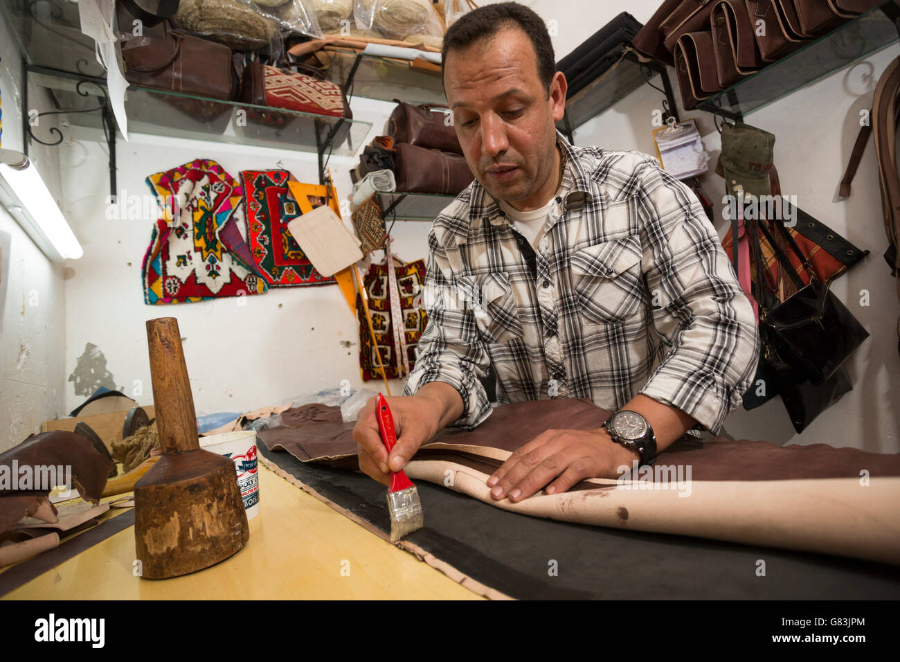 A leather artisan works in his workshop in the Marrakesh Medina, Morocco. Stock Photo