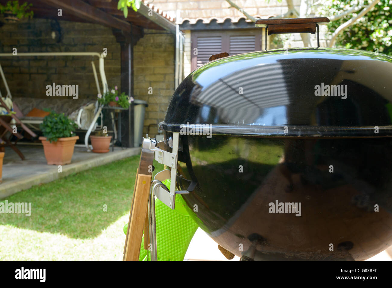 A closed barbecue during pulled pork cooking day, with tools Stock
