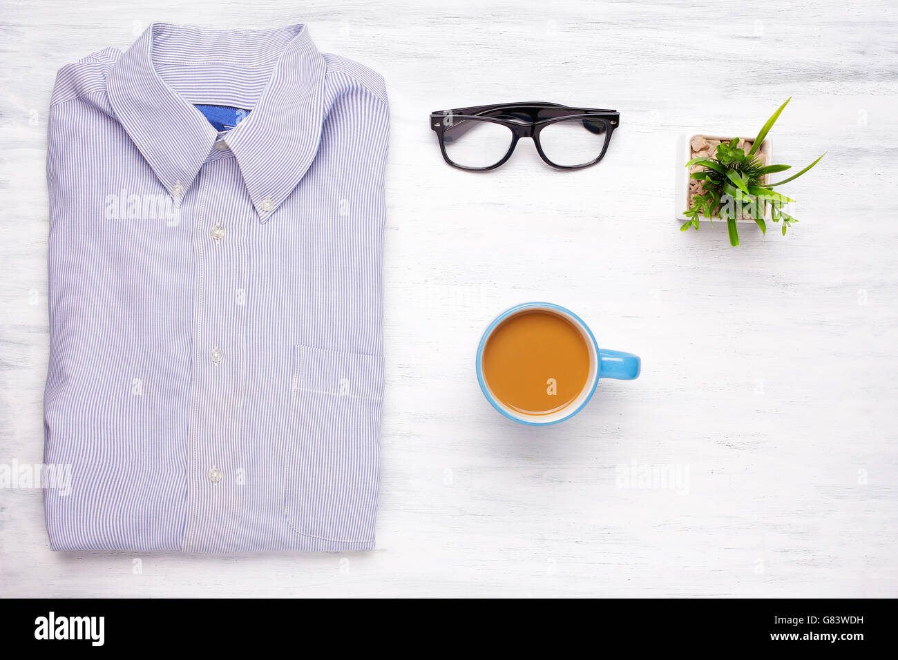Businessman shirt, cup of coffee and hipster glasses on white wooden background. Business and office concept. Lifestyle. Stock Photo
