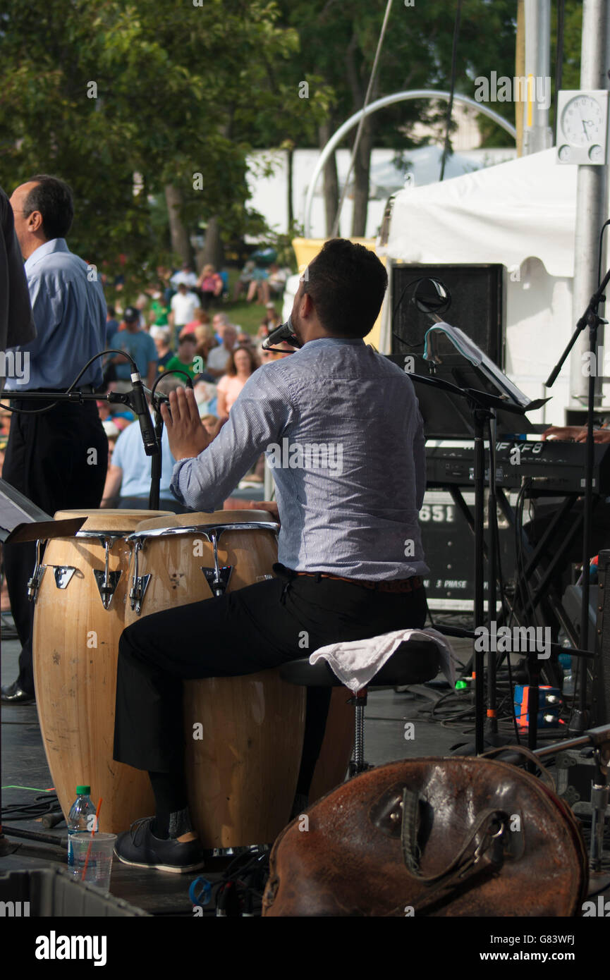 Vocalist and percussionist playing congo drums for Mitch Frohman & The