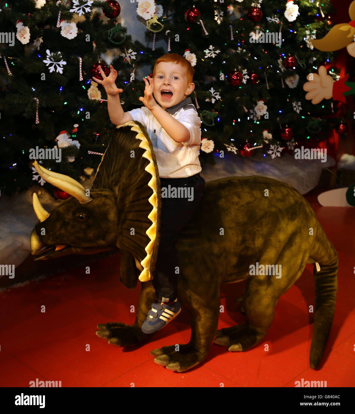 Four-year-old Tristan (no surname given) plays with a Triceratops sit-on dinosaur as Hamleys launches its Christmas toy range in central London. Even the youngest children will need their technological know-how up to speed when Father Christmas visits this year, according to the top toy predictions from Hamleys. Stock Photo