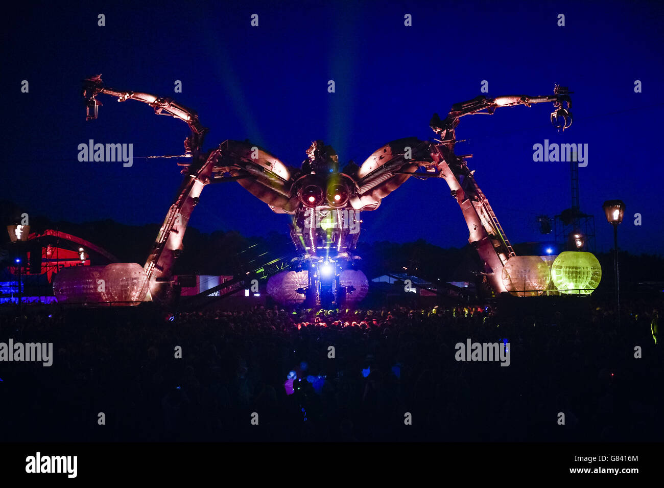 Revellers dance underneath Arcadia Spectacular huge mechanical spider at the Glastonbury Festival, at Worthy Farm in Somerset. Stock Photo
