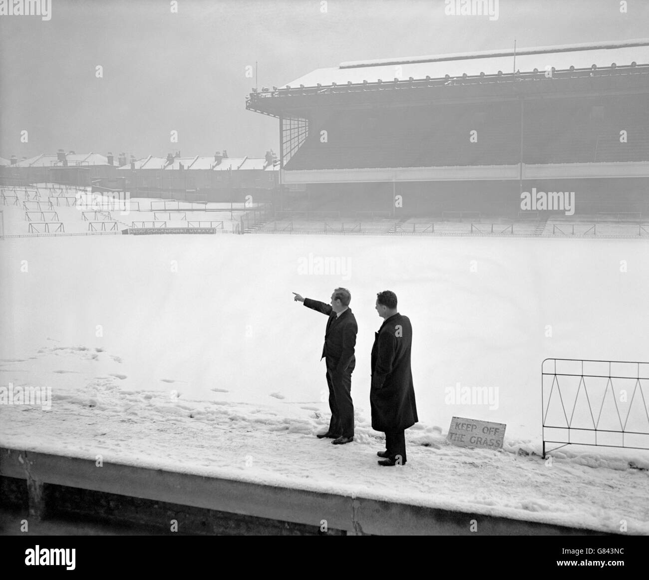 Arsenal manager Billy Wright (l) makes a point to referee AJ Sturgeon (r) after the latter had no option but to postpone Arsenal's match due to the heavy covering of snow on the Highbury pitch. Stock Photo