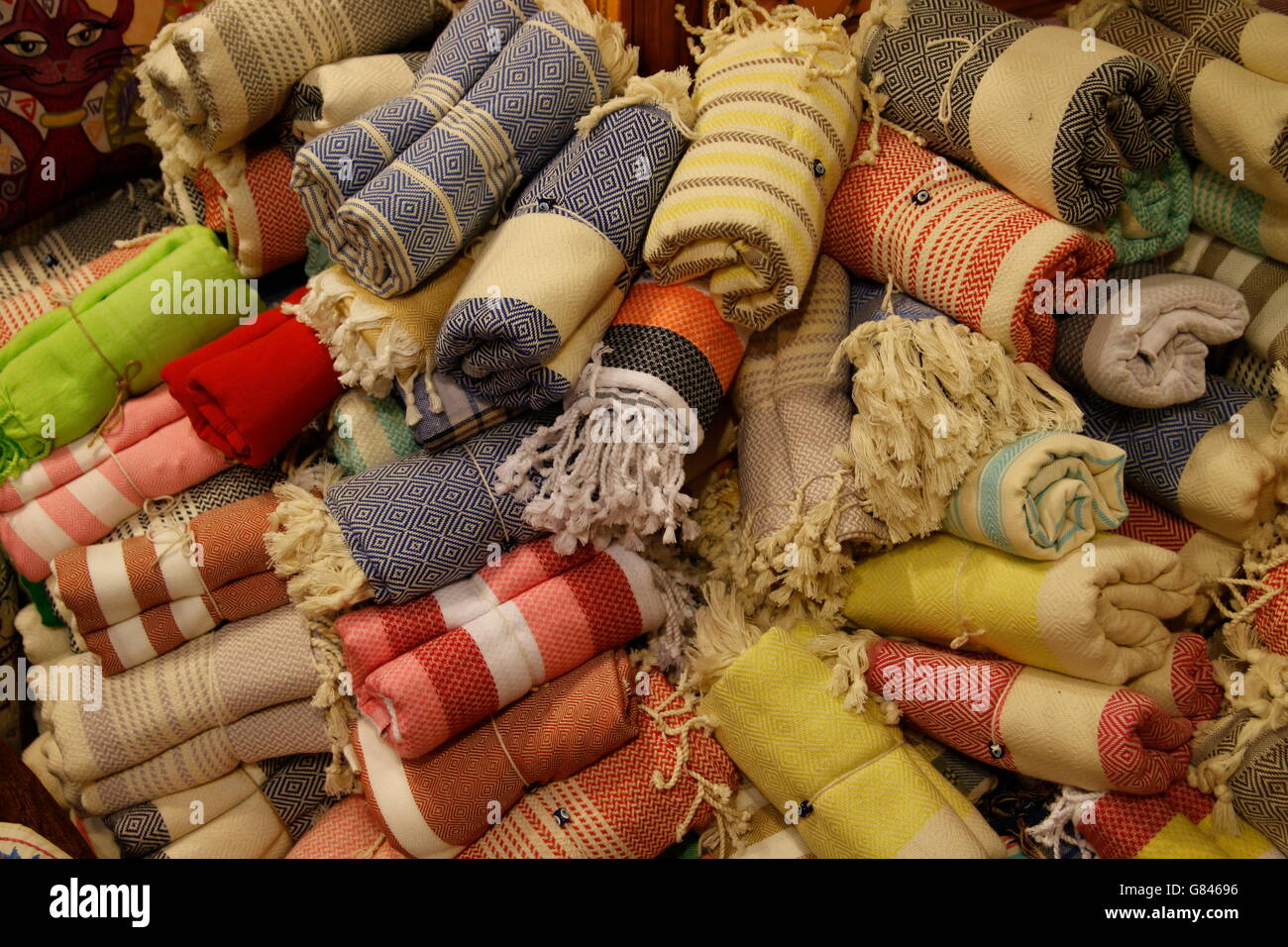 A collection of rolled turkish towels for sale in a local market in