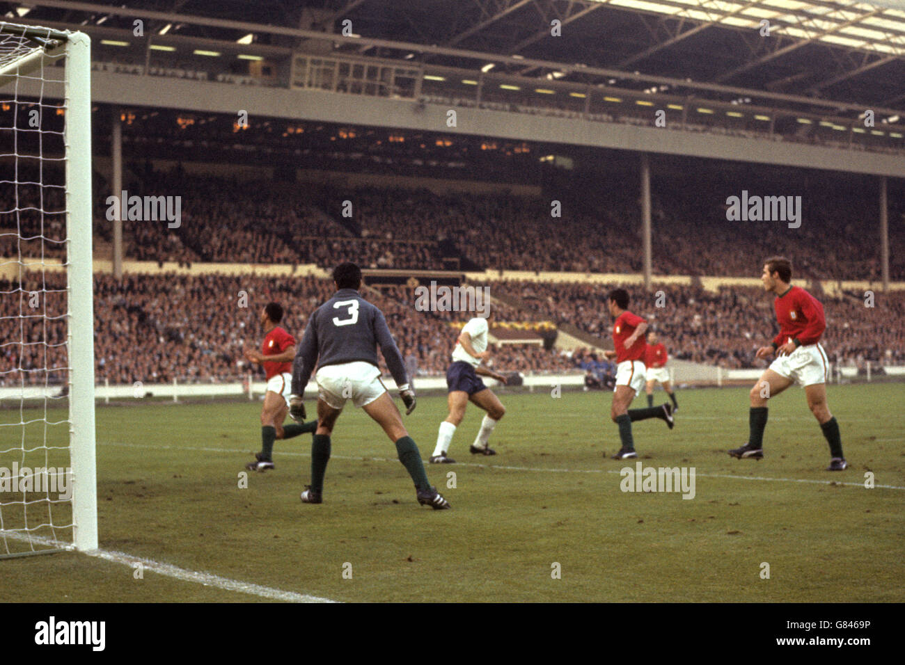 England attack Portugal's goal. Roger Hunt watches the ball pass under him. The Portugal goalkeeper is Jose Pereira. Stock Photo